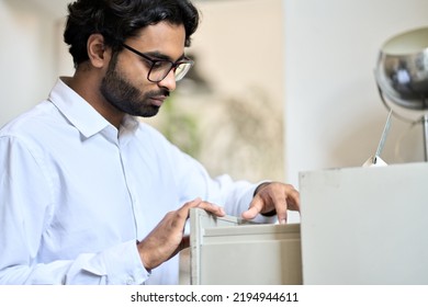 Indian Business Man Searching Corporate Documents In Archive Drawer. Files Reference Directory Administrator Accountant Looking For Papers, Doing Paperwork, Organizing Folders Accounting Storage.