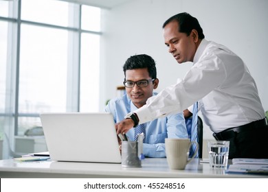 Indian Business Team Discussing Information On Tablet Computer