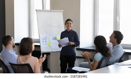 Indian businesslady trainer finish presentation on flip chart for corporate staff, accomplish training, employees applauding express gratitude for received information. Seminar, recognition concept - Powered by Shutterstock