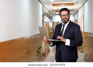 Indian businessman using laptop at office. - Powered by Shutterstock