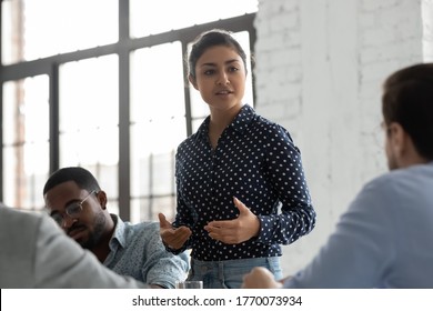 Indian businesswoman negotiates with clients showing persuasion skills during formal meeting feels confident. Business coach provide helpful information at workshop. Negotiations, leadership concept