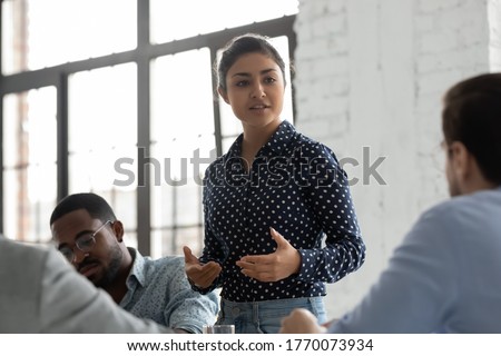Indian businesswoman negotiates with clients showing persuasion skills during formal meeting feels confident. Business coach provide helpful information at workshop. Negotiations, leadership concept [[stock_photo]] © 