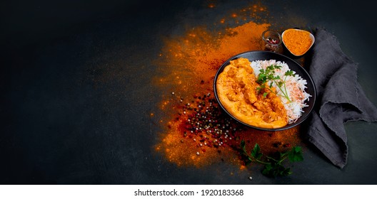 Indian butter chicken curry with basmati rice on dark background. Traditional homemade food concept. Top view, copy space