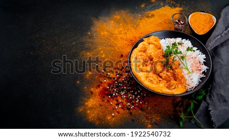 Indian butter chicken curry with basmati rice on dark background. Traditional homemade food concept. copy space