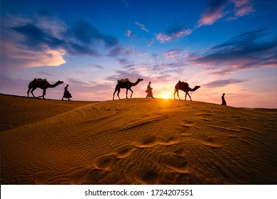 Cameleros indios (camelleros) bedouin con siluetas de camellos en dunas de arena del desierto de Thar al atardecer. Caravana en Rajastán viajes turismo de fondo aventura safari. Jaisalmer, Rajasthan, India