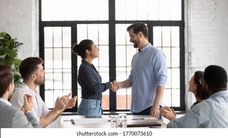 Indian and caucasian business people shake hands start negotiations with partners at boardroom. Staff cheering best employee of month receive praises, gratitude from boss, worker get promotion concept - Shutterstock ID 1770073610