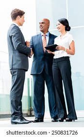 Indian CEO And Caucasian Executive Having Business Handshake In Front Of City Skyline