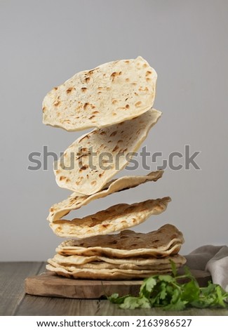 Indian chapati flatbread with cilantro, creative photography with levitation. High quality photo