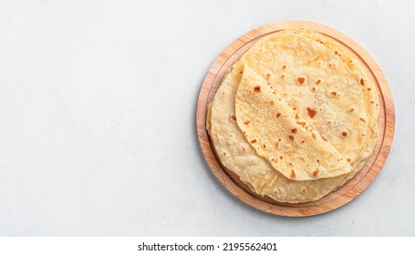 Indian chapati tortillas on a wooden board on a gray background. Traditional Indian food. Top view, copy space - Shutterstock ID 2195562401