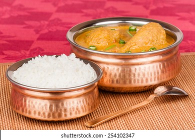 Indian Chicken Curry Served With Rice In Authentic Copper Utensils. Green Chilli Used As Garnish. Shallow Depth Of Field.