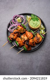 Indian chicken tikka kebabs, marinated in spices and yogurt and roasted in tandoor. served with green chutney and onion. selective focus