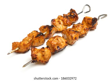Indian chicken tikka kebabs on metal skewers.