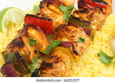 Indian chicken tikka kebabs with red onions and peppers.