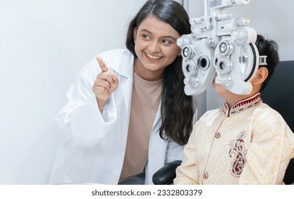 Indian child boy doing subjective refraction with diagnostic ophthalmology equipment, phoropter with ophthalmologist or optometrist or doctor for eyes vision exam test at hospital or clinic - Powered by Shutterstock