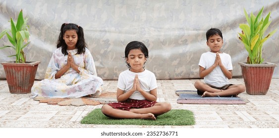 Indian children doing yoga and meditation at home on the floor. Kids child in pray pose.
 - Powered by Shutterstock