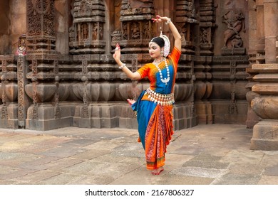 Indian classical Odissi dancer looks at the mirror during the Odissi dance recital against the backdrop of temple sculpture.art and culture of india.  - Shutterstock ID 2167806327