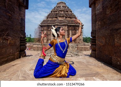 Indian classical odissi dancer or orissi dancer wears traditional costume and posing in front of Konark Sun Temple, Konark, Odisha, India - Powered by Shutterstock