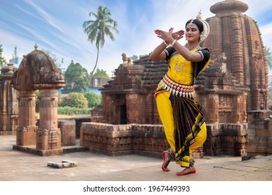 Indian classical Odissi dancer posing in front of 10th century Mukteshvara temple. Odissi dance is a major ancient Indian traditional dance form originated in the Hindu temples of Odisha. - Shutterstock ID 1967449393