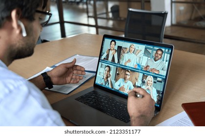 Indian Corporate Leader Manager Leading Virtual Business Team Work Meeting, Diverse Workers Group Conference Online Remote Video Call. Over Shoulder Videoconference On Laptop Screen View