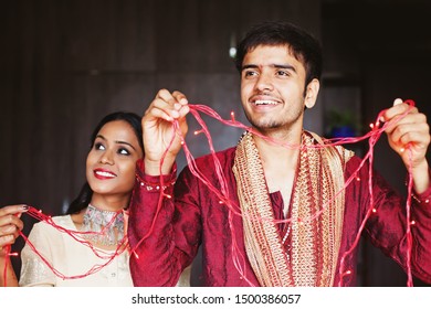 Indian couple decorating their house for Diwali / Christmas celebration