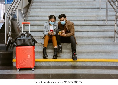 Indian Couple Wearing Face Masks Using Mobile Phones In Airport Indoors