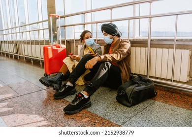 Indian Couple Wearing Face Masks Talking And Using Mobile Phones In Airport Indoors