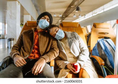 Indian Couple Wearing Face Masks Sleeping While Sitting In Airport Indoors