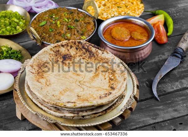 Indian Cuisine Chapati Also Called\
Roti, Flatbread, Chapathi or Chapatti Served With Sev Tamatar,\
Gatta Curry, Raita, Papad or Onion on Wooden\
Background