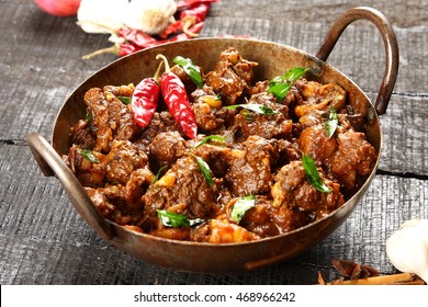 Indian cuisine-Famous Indian mutton or lamb curry dish in a cast iron cookware. Selective focus photograph.