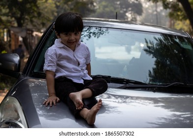 Indian Cute Baby Boy Sitting On Car Bonnet