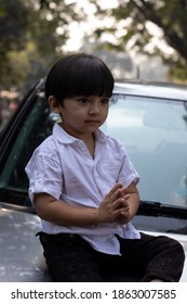 Indian Cute Boy Sitting On Car Bonnet