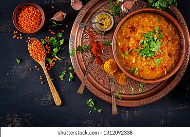 Indian Dal. Food. Traditional Indian Soup Lentils.  Indian Dhal Spicy Curry In Bowl, Spices, Herbs, Rustic Black Wooden Background. Top View. Authentic Indian Dish. Overhead. Flat Lay