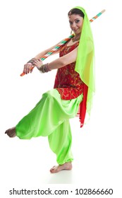 Indian dancer in traditional beautiful green and red dress with veil and sticks