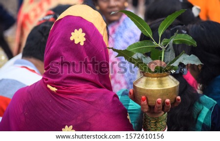 Indian devotee woman worship of sun with holy pot, selective focus used.
