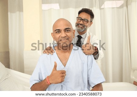 Indian doctor with happy cancer patient in hospital. Asian healthcare cancer concepts
