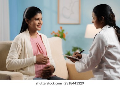 Indian doctor or nurse counseling pregnant woman at home by writing report at home - concept of home health checkup, maternity assistance and medicare support - Powered by Shutterstock