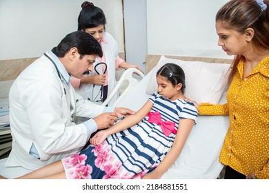 Indian Doctor Taking Blood Sample Of Little Girl Child At Hospital.