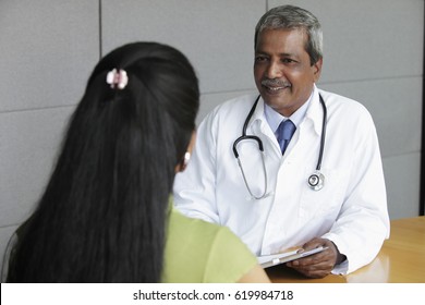 médico indiano falando com paciente feminino