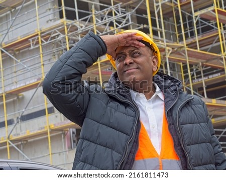 Indian engineer scrutinising the construction site