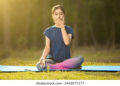 indian ethnicity women concentrating on pranayama meditation by focusing on breath inhale and exhale and sitting in a ardha padmasana position, eyes closed - Powered by Shutterstock