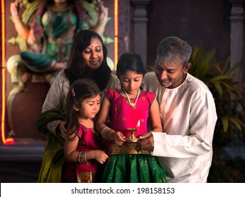indian family celebrating diwali ,fesitval of lights inside a temple
