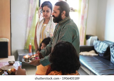 Indian Family Celebrating Diwali Or Hindu Festival At Home - Focus On Man Face