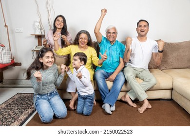 Indian family celebrating winning while watching tv at home - Powered by Shutterstock