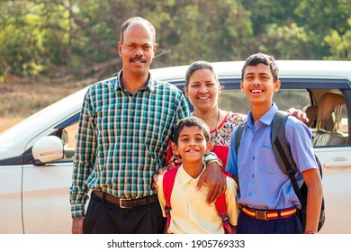 Indian Family Driving Boys To School In Front Of House Gates