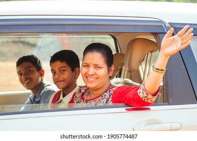 Indian Family Driving Boys To School In Front Of House Gates