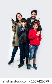 Indian Family Eating Ice Cream In Warm Clothes On White Background