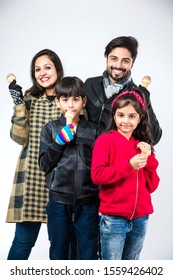 Indian Family Eating Ice Cream In Warm Clothes On White Background