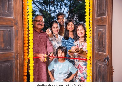 Indian family entering new home called gruhapravesh with puja thali and keys - Powered by Shutterstock