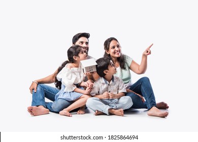 Indian Family Father, Mother, Son And Daughter Holding 3D Paper Model Of Home - Real Istate Concept In India