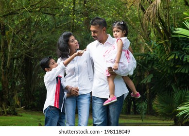 Indian Family At Outdoor. Parents And Children Walking On Garden Path. Exploring Nature, Leisure Lifestyle.